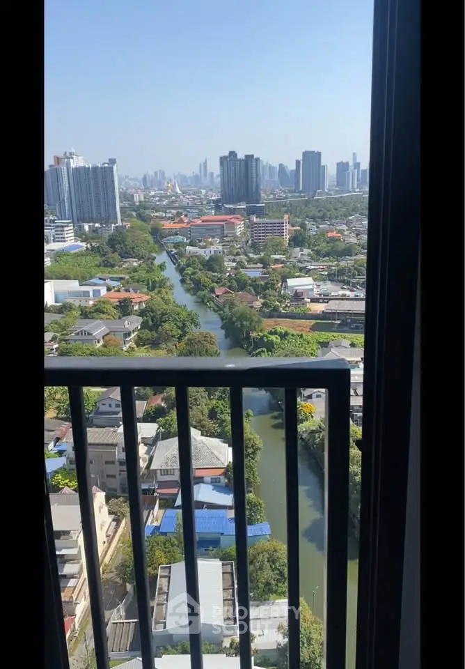 Stunning cityscape view from a high-rise balcony overlooking a serene river and urban skyline.