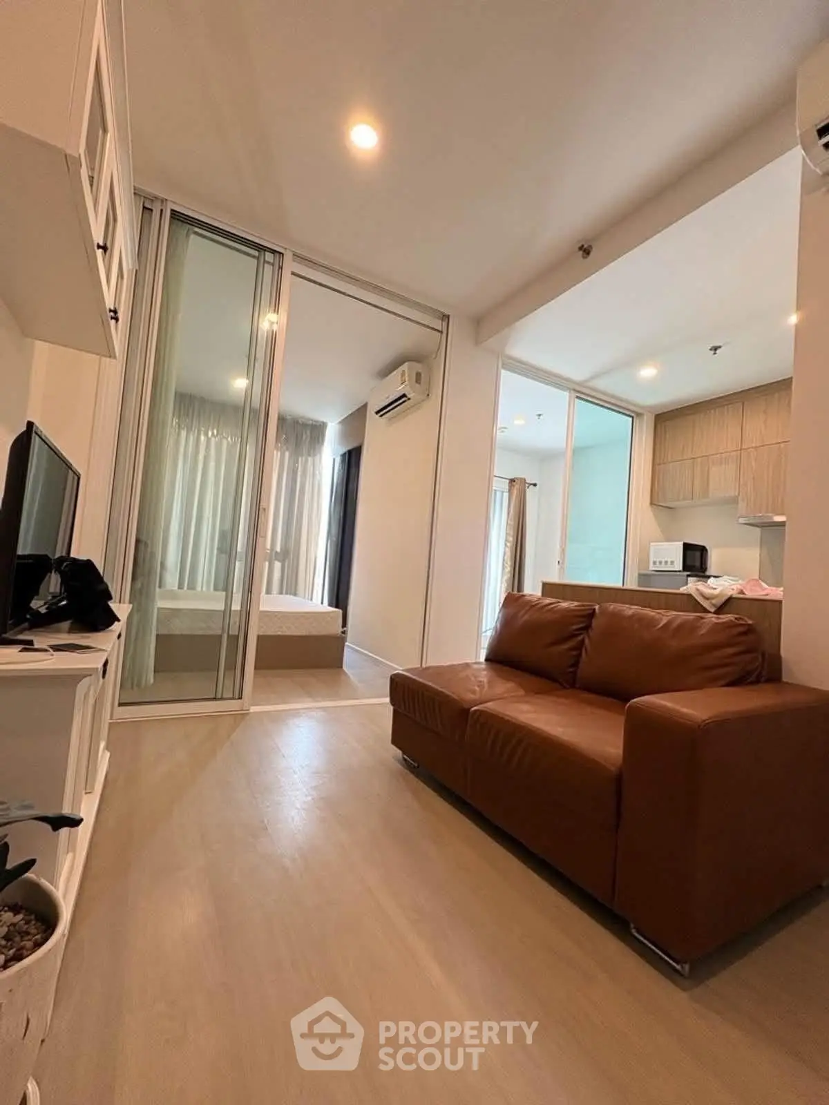 Modern apartment interior with cozy living room and open kitchen layout, featuring stylish furniture and natural light.