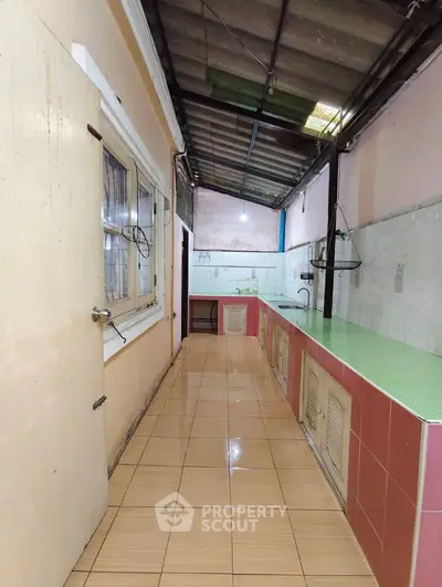 Narrow kitchen with tiled floor and countertop in a cozy home setting