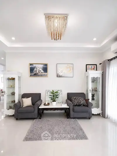 Elegant living room with plush seating, modern chandelier, and stylish decor in a bright, airy space.