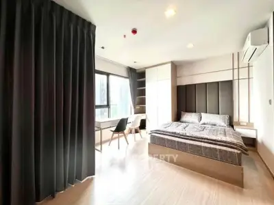 Spacious modern bedroom with large window and stylish decor