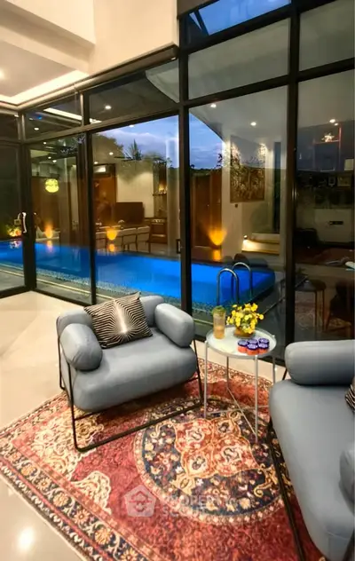 Luxurious living room with pool view, modern furniture, and elegant decor in a contemporary home.