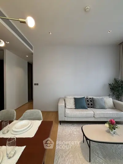 Modern living room with elegant dining area, cozy sofa, and stylish decor in a bright, open space.