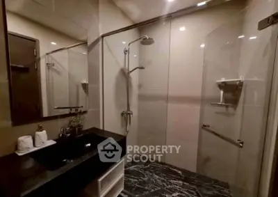 Modern bathroom with sleek glass shower and elegant black countertop