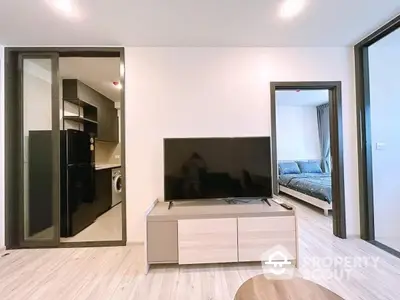 Modern apartment interior with open living room and kitchen, featuring sleek appliances and stylish decor.