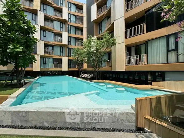 Luxurious modern apartment complex with stunning pool and lush greenery.