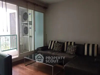 Stylish living room with modern sofa and balcony view, perfect for urban living.