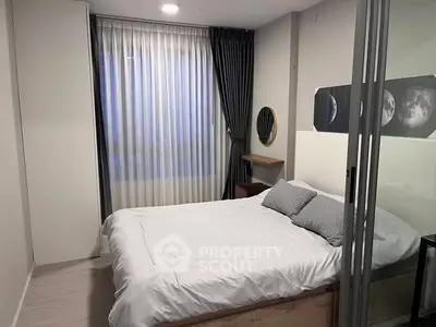Modern bedroom with stylish decor and large window, featuring a cozy bed and elegant curtains.