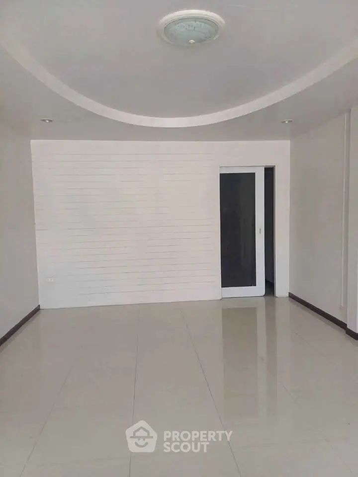 Spacious empty room with modern ceiling and tiled floor, ready for customization.