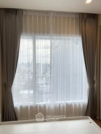 Spacious apartment window with city view and elegant curtains