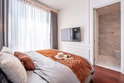 Luxurious bedroom with ensuite bathroom, featuring elegant decor and natural light.