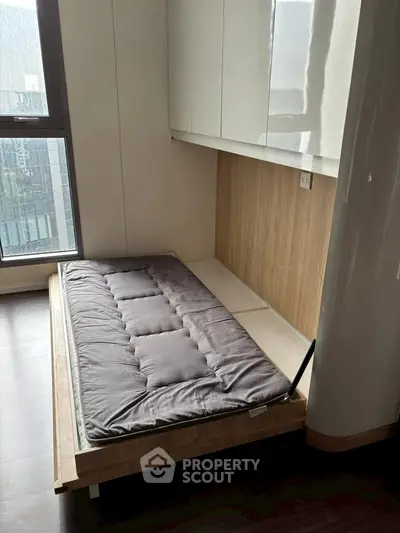 Modern bedroom with foldable bed and large window offering city view