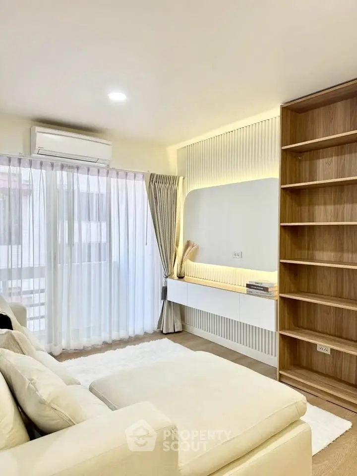 Modern living room with built-in shelves and large window for natural light.