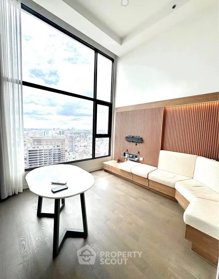 Stunning modern living room with floor-to-ceiling windows offering breathtaking city views.