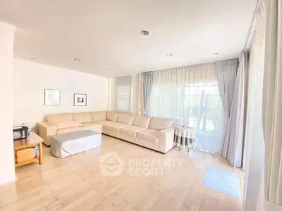Spacious living room with large windows and elegant curtains