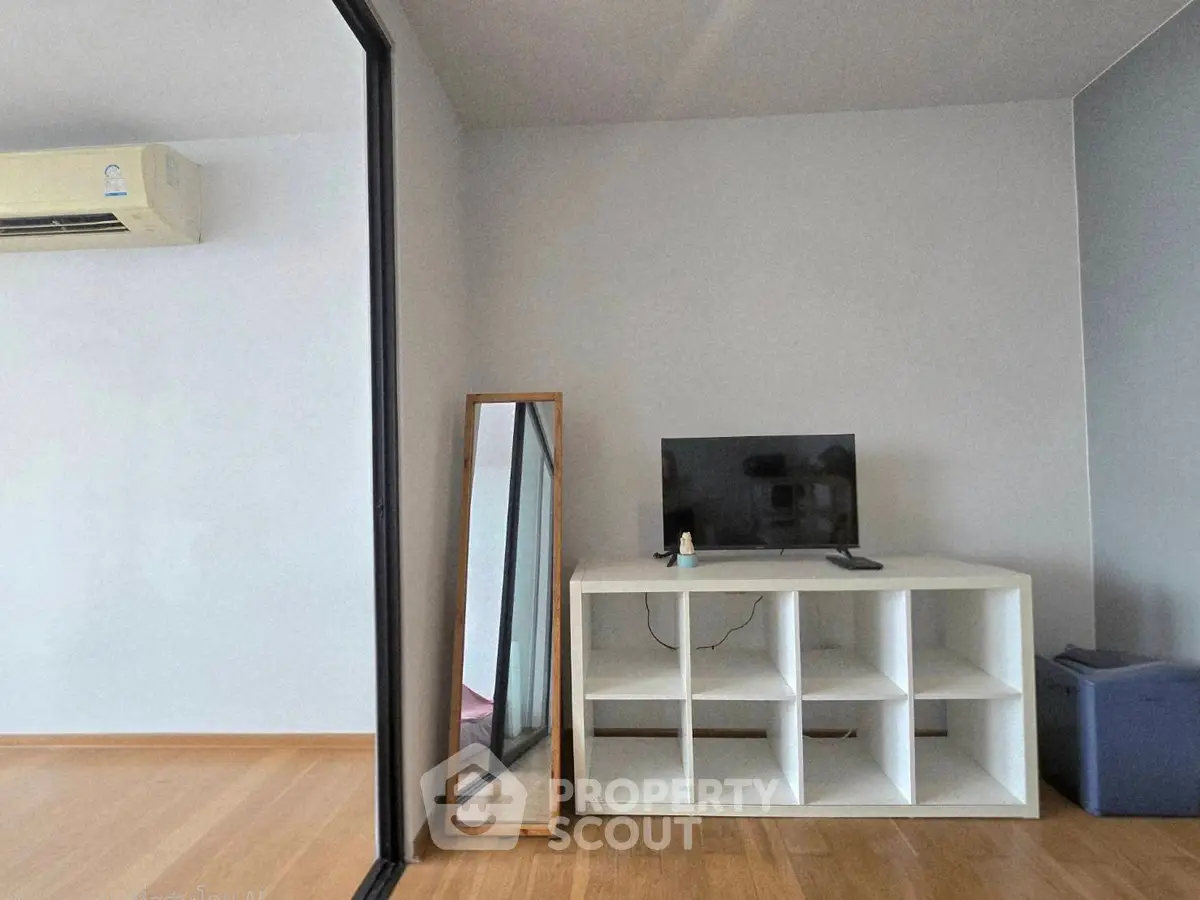 Modern minimalist living space with air conditioning and sleek shelving unit.