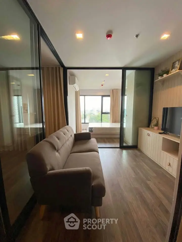 Modern living room with glass partitions and cozy sofa in stylish apartment.