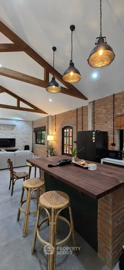 Stunning open-layout kitchen with rustic charm and modern lighting, featuring a spacious island and cozy seating.
