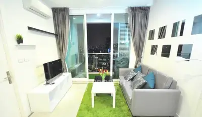 Modern living room with city view, sleek furniture, and vibrant decor in a high-rise apartment.
