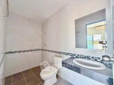 Spacious modern bathroom with sleek fixtures and large mirror, perfect for a contemporary home.