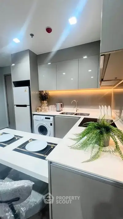 Modern kitchen with sleek cabinetry, integrated appliances, and stylish dining setup.