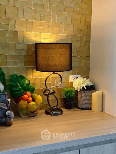 Stylish kitchen corner with modern lamp and fruit bowl on wooden countertop.