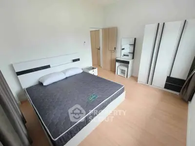 Spacious bedroom with modern furniture and ample natural light