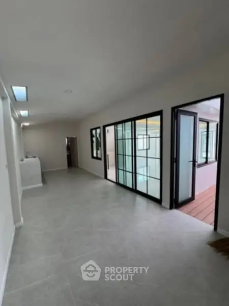 Spacious modern hallway with glass doors and sleek tile flooring