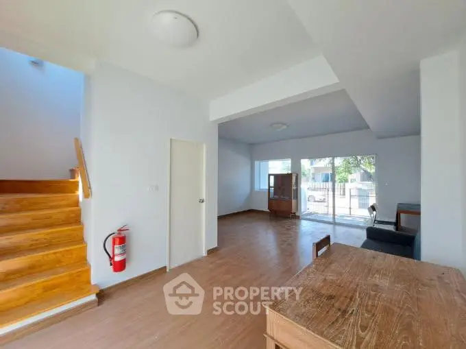 Spacious open-plan living area with wooden floors and natural light.