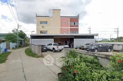 Commercial building with parking area and colorful facade in urban setting.