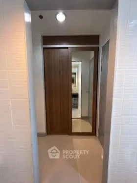 Modern hallway with sleek wooden closet and mirrored sliding doors