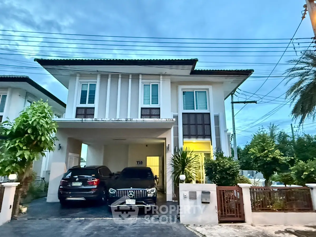 Elegant two-story house with modern facade and spacious driveway at dusk