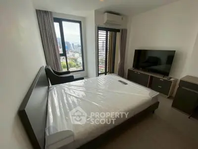 Modern bedroom with city view, featuring a large window, sleek furniture, and a wall-mounted TV.