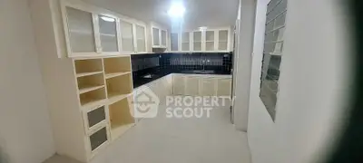 Spacious kitchen with modern cabinetry and sleek black backsplash