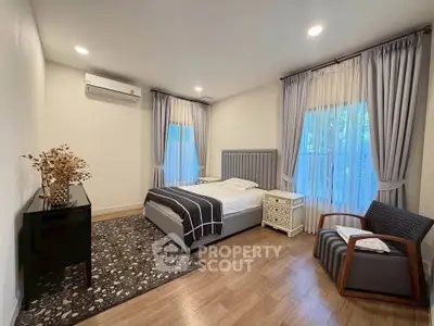 Spacious bedroom with elegant decor and natural light, featuring a cozy bed and stylish furnishings.