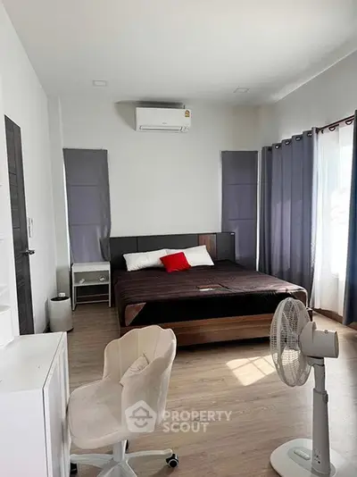 Spacious bedroom with modern decor and natural light