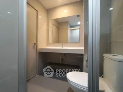 Modern bathroom with sleek fixtures and large mirror in contemporary apartment.