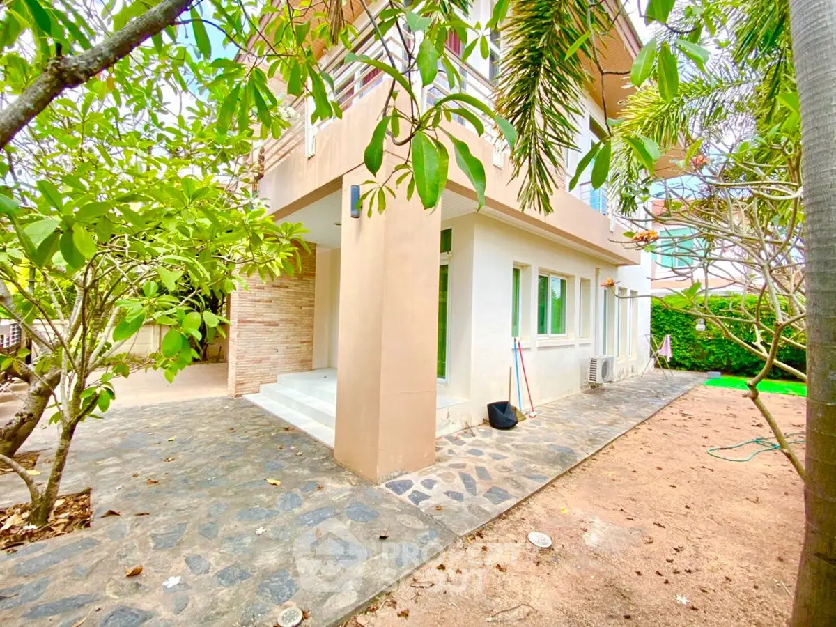 Charming two-story home with lush garden and spacious patio, perfect for outdoor living and relaxation.