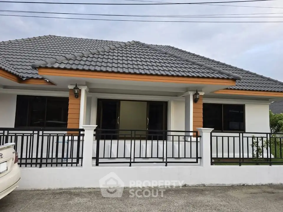 Charming single-story house with modern roof and inviting porch, perfect for family living.