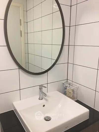 Modern bathroom with sleek white tiles and stylish oval mirror