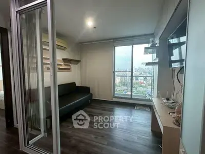 Modern living room with city view, sleek flooring, and stylish furniture in a high-rise apartment.