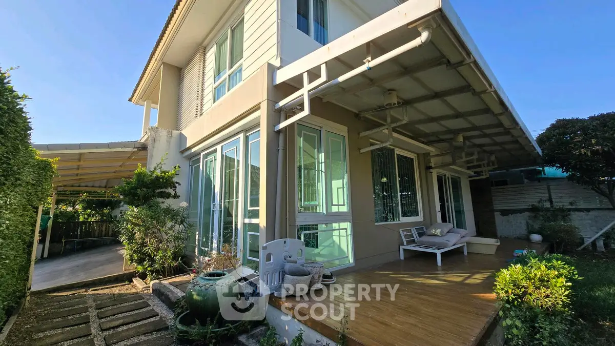 Charming two-story house with spacious garden and cozy patio area, perfect for family living.