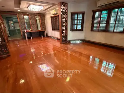 Spacious polished living room with wooden flooring and elegant lighting, perfect for modern living.