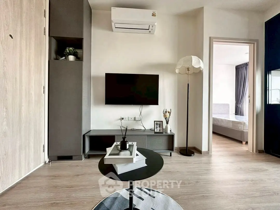 Modern living room with sleek design and open view to bedroom