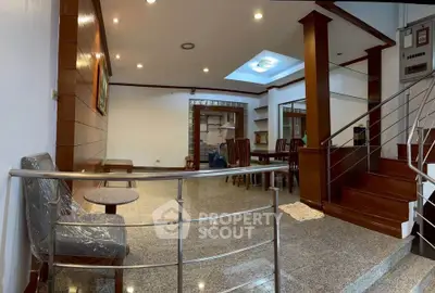 Spacious open-plan living and dining area with modern staircase and natural light.