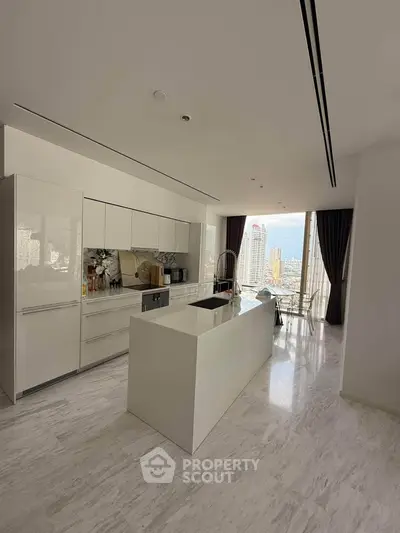 Luxurious modern kitchen with sleek white cabinetry and stunning city view from large windows.