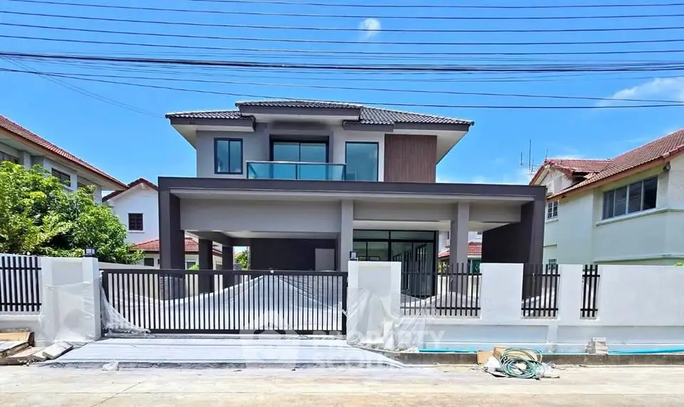 Modern two-story house with sleek design and spacious driveway in a suburban neighborhood.