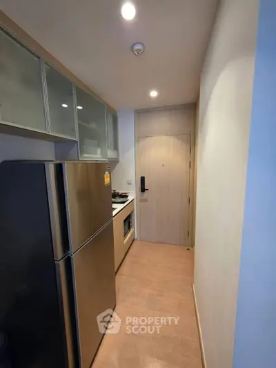 Modern compact kitchen with stainless steel appliances and sleek cabinetry