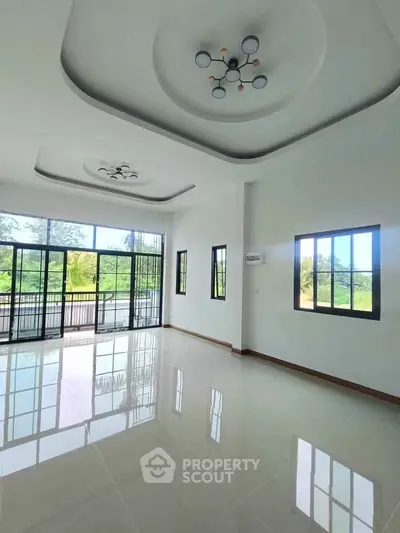 Spacious modern living room with large windows and stylish ceiling lights