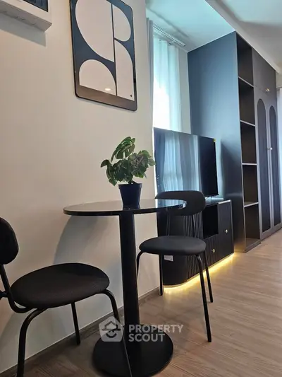 Modern living room with stylish decor and natural light, featuring a cozy seating area and sleek furniture.
